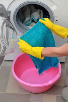 woman taking color clothes from washing machine