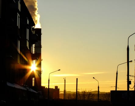 High Chimney emits a large amount of Smoke in Industrial District of Vilnius City in Lithuania during the Sunset