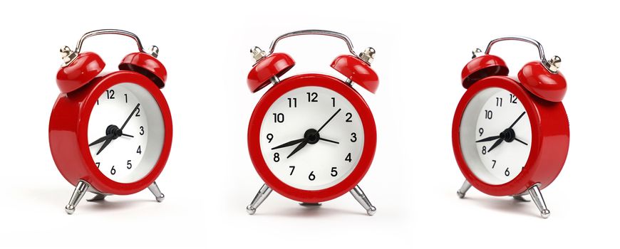 Three small red metal alarm clock with red bells over white background, close up, low angle view in different perspectives