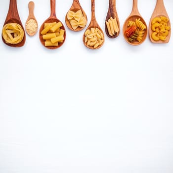 Italian foods concept and menu design. Various kind of Pasta Farfalle, Pasta A Riso, Orecchiette Pugliesi, Gnocco Sardo and Farfalle in wooden spoons setup on white wooden background with flat lay.