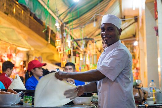 A malaysian chef is baking on street with smile