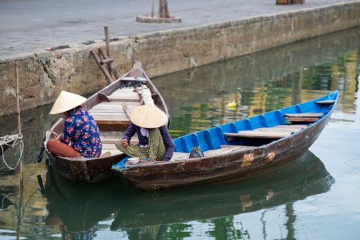 Unidentified woman on boats on Thu Bon river in ancient Hoian town. Hoian is recognized as a World Heritage Site by UNESCO