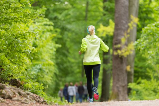 Sporty young female runner in forest.  Running woman. Female runner during outdoor workout in nature. Fitness model outdoors. Weight Loss. Healthy lifestyle. 