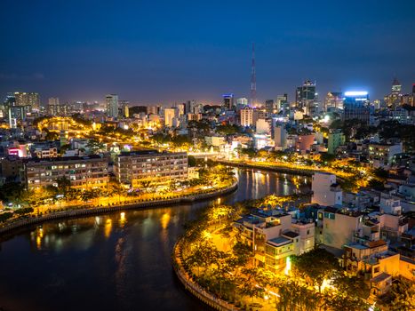 Aerial night city view of houses and Business Center of Ho Chi Minh city on Nhieu Loc canal