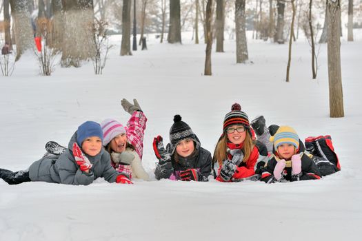 Happy children in winterwear laughing while playing in park