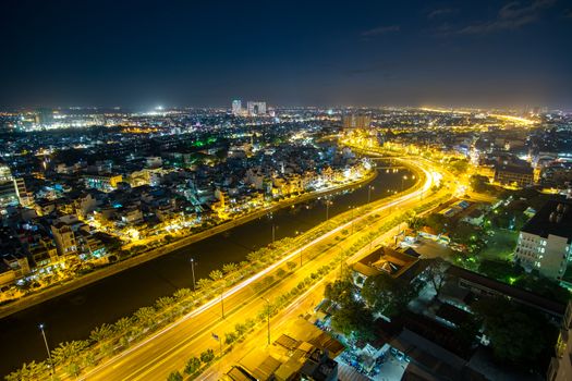 Colourful night city with clouds on Tau Hu canal and the East-West Highway (Vo Van Kiet street) in Ho Chi Minh City (Saigon).View from a roof of building