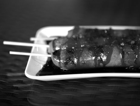 BLACK AND WHITE PHOTO OF SAUSAGES WITH SPICY SAUCE