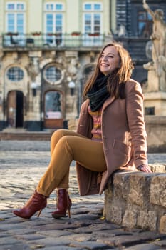 pretty girl sits on a rock in the city in the morning