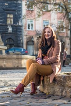 pretty girl sits on a rock in the city in the morning