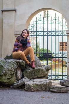 pretty girl sits on a rock in the city in the morning