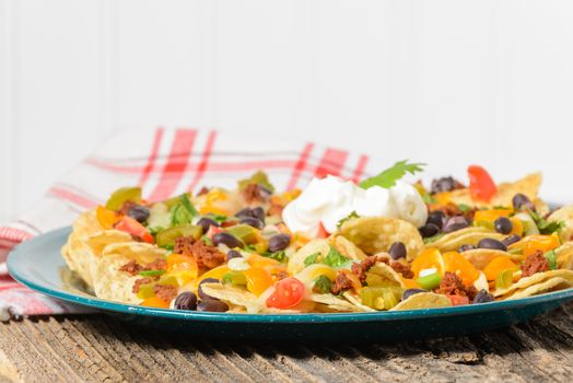 Plate of colorful nachos and cheese photographed closeup.