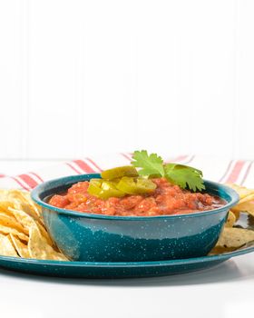 Bowl of spicy salsa garnished with jalapeno and cilantro.