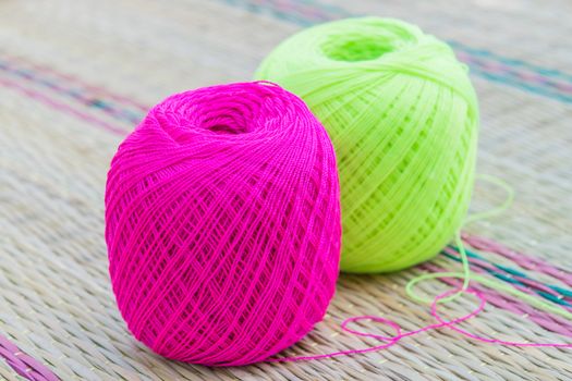 balls of pink and green knitting yarn