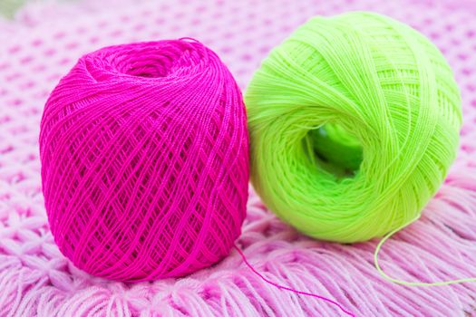 balls of pink and green knitting yarn