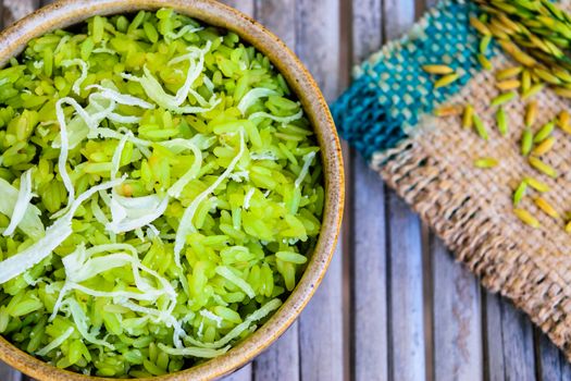 shredded rice grain with coconut, traditional Thai dessert on old wooden table