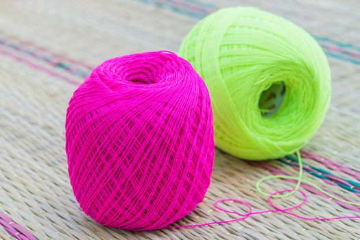 balls of pink and green knitting yarn