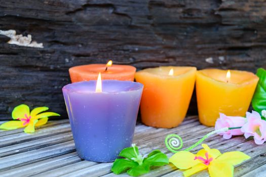 candles and flowers plastic beautiful on bamboo table on old wood background