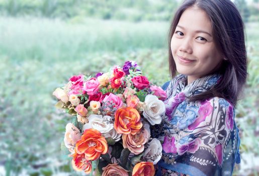 woman holding flowers bouquet in hand and smiling 