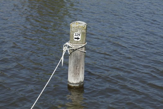 wooden peg with rope in a harbour