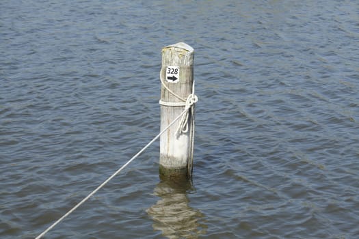 wooden peg with rope in a harbour