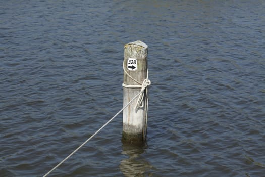 wooden peg with rope in a harbour