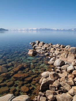 Scenic view of beautiful Lake Tahoe in Spring, landscape of the United States of America, clear water, nice sky, stone island, tree, fresh air and snow mountains