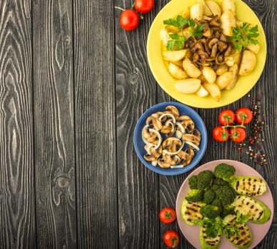 Diet vegetables grilled on a dark wooden table. Tasty, healthy, rich in vitamins and minerals: potatoes, mushrooms,tomato, broccoli, pepper, squash. Top view.