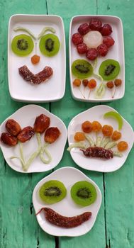 Vietnamese food for Vietnam Tet holiday, also lunar new year of Asia, colorful preserved fruit as kiwi, damson jam, or coconut jam set up on white plate with green wood background make art