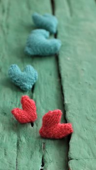 Abstract valentine background with red heart on green wooden in vintage color, knitted heart is symbol for romantic love of couple in feb 14