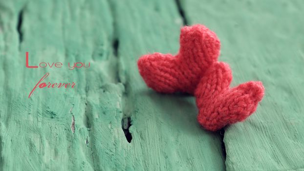 Abstract valentine background with red heart on green wooden in vintage color, knitted heart is symbol for romantic love of couple in feb 14