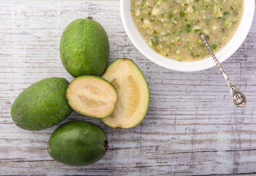 feijoa and feijoa jam in a white bowl on a white wooden table