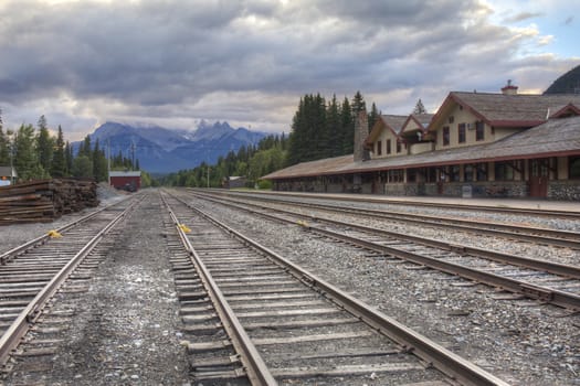 Railway tracks run past the historic Banff Train Station - Banff, Alberta, Canada