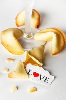 Cookies shaped like tortellini with the word love written on a paper and a glass of champagne.Vertical image.