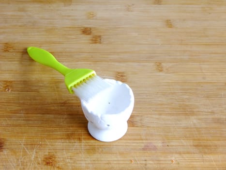 Green Brush and Egg Holder on wooden Cutting Board