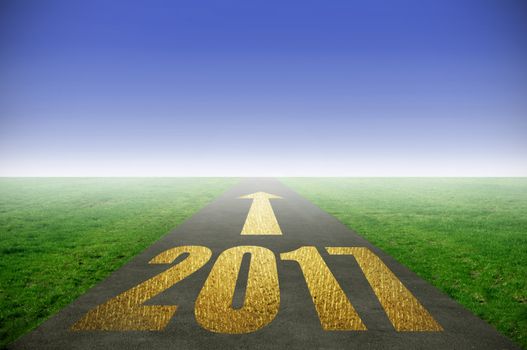 2017 printed in gold on road with green grass on each side