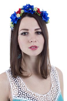 Portrait of a girl in a wreath of flowers on a white background