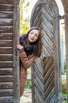 beautiful girl near old wooden gate in the city