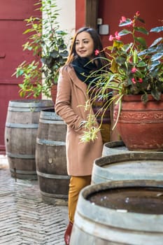 beautiful girl from wooden barrels with flowers in the city