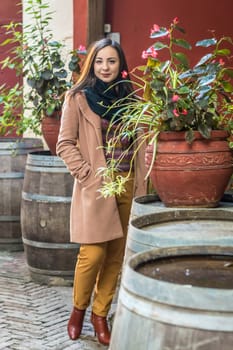 beautiful girl from wooden barrels with flowers in the city