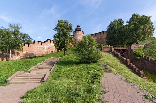 Tower and wall of Kremlin in Nizhny Novgorod on blue sky background view from the bottom of the stairs.