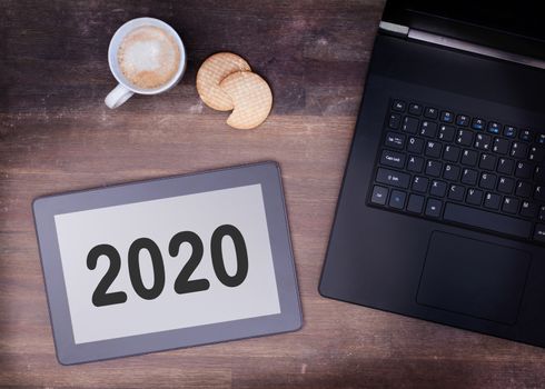 Tablet touch computer gadget on wooden table, vintage look - 2020