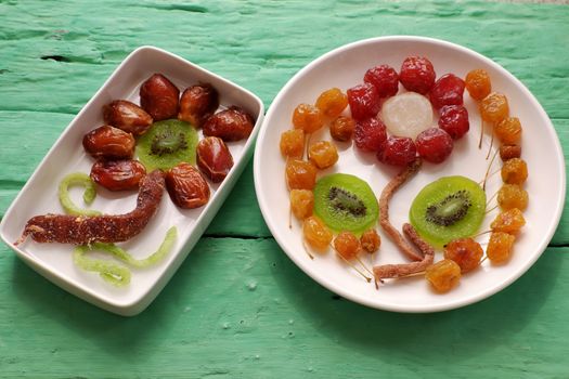 Group of colorful Vietnamese jam for Vietnam Tet holiday on green background, also lunar new year of Asia, traditional preserved fruit from kiwi, damson or coconut jam