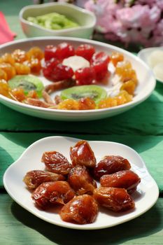 Group of colorful Vietnamese jam for Vietnam Tet holiday on green background, also lunar new year of Asia, traditional preserved fruit from kiwi, damson or coconut jam