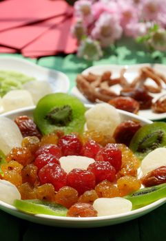 Close up of colorful Vietnamese jam for Vietnam Tet holiday on green background, also lunar new year of Asia, traditional preserved fruit from kiwi, damson or coconut jam