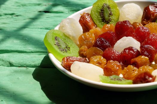 Close up of colorful Vietnamese jam for Vietnam Tet holiday on green background, also lunar new year of Asia, traditional preserved fruit from kiwi, damson or coconut jam