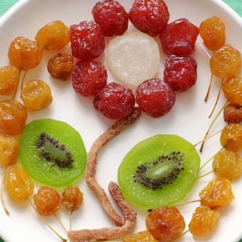 Close up of colorful Vietnamese jam for Vietnam Tet holiday on green background, also lunar new year of Asia, traditional preserved fruit from kiwi, damson or coconut jam