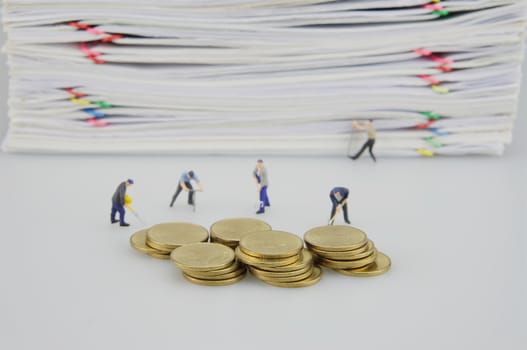 Pile overload document and gold coins with miniature people on white background.