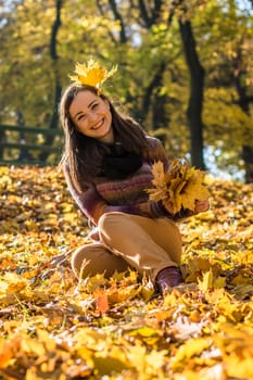 beautiful girl in autumn Park keeps yellow leaves