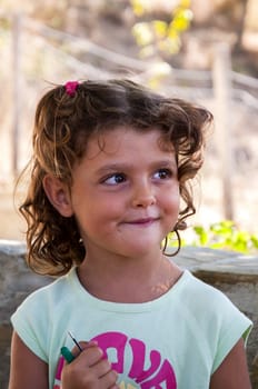 a beautiful little girl smiling with sly expression