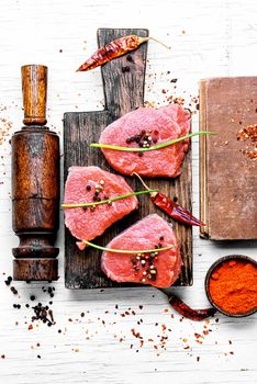 Three raw chops veal steak with peppers and spices